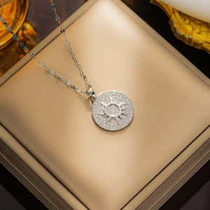 Silver sun disc necklace with cubic zirconia on gold jewelry box for women