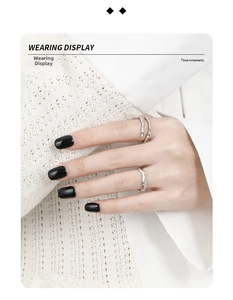 Detail shot of dual-layer minimalist S925 silver rings with organic wavy lines on fingers