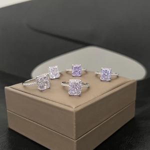 Dettaglio di cinque anelli in argento S925 con diamanti rosa su una scatola di pelle marrone