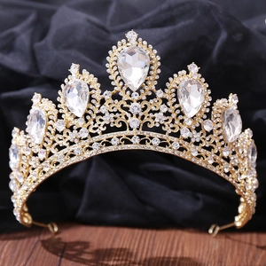 Detailed view of rhinestone bridal crown with gold metal frame on black background