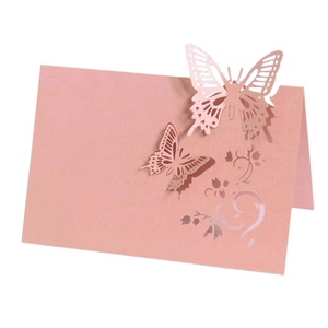 Elegant laser-cut butterfly place cards in rose gold with intricate floral patterns