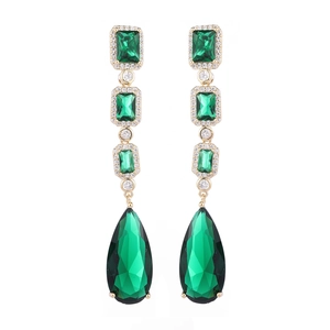 Elegant gold drop earrings with green teardrop stones and zircon accents on white background
