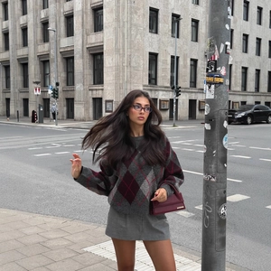 Women's vintage argyle knit sweater in grey and red with diamond patterns in street view
