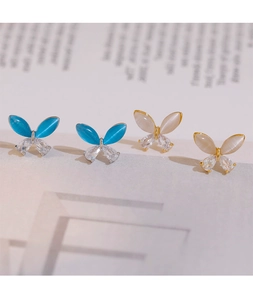 Detailed macro view of 925 silver butterfly earrings with cat eye stones and zircons