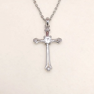 Silver cross pendant necklace with clear cubic zirconia crystals on white background