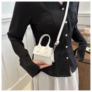 Detailansicht einer weißen Mini-Handtasche aus PU-Leder mit Griff und Riemen von Model