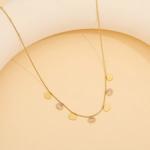 Détail du collier en acier doré avec pendentifs en pierre œil de chat rose et breloques
