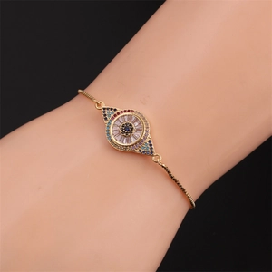 Bracelet œil maléfique ajustable en or avec zircons colorés porté par un mannequin