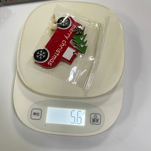 Contrôle qualité du camion de Noël en bois rouge pesant 5,6 g sur une balance