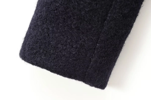 Detail of navy double-breasted wool coat showing textured fabric and stitching