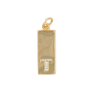 Detail of gold rectangular pendant with Zircon letter T on polished surface