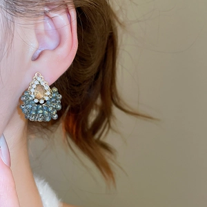 Gros plan de boucles d'oreilles élégantes en cristal champagne et perles gris-bleu
