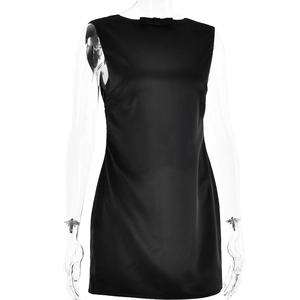 Detalle del vestido corto de satén negro con cuello de lazo y textura suave y lisa