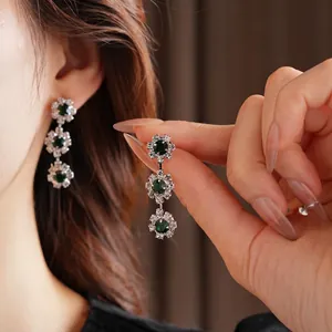 Three-tiered emerald sunflower drop earrings with sparkling crystals for elegant evening wear