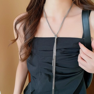 Silver multi-layer chain necklace with knot detail and long tassel on a model