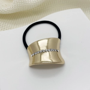 Detailed shot of golden alloy hair tie with sparkling rhinestone inlay and elastic band