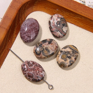 Close-up of oval natural stone beads with leopard print textures for DIY jewelry making