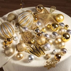 Golden and silver Christmas tree ornament set with stars and baubles on a cozy knit blanket