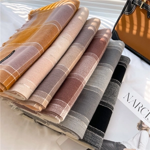 Stacked plaid cashmere scarves in various colors with soft fringe detail and labels