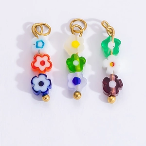 Detailed view of colorful flower-shaped bead charms with gold plated connectors for jewelry