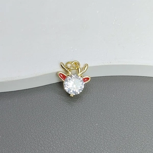 Macro shot of gold reindeer pendant featuring clear zircon and red enamel details