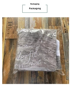 Gray velvet Christmas tree skirt featuring festive letter embroidery in plastic packaging