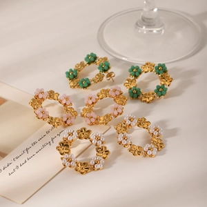Détail de boucles d'oreilles créoles fleurs ajourées avec perles colorées