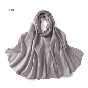 Detailed view of silver grey satin scarf texture with elegant pearlescent sheen and drape