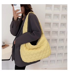 Detail showing soft quilted yellow cloud bag texture and spacious shoulder strap design
