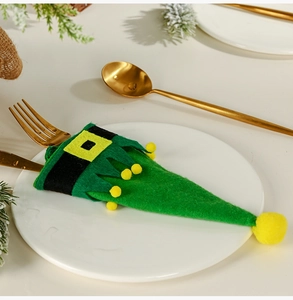 Close-up of green elf shoe cutlery holder with felt fabric and belt detail on a plate