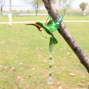 Detailed close-up of a hummingbird crystal wind chime hanging from a natural tree branch