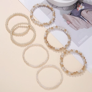 Nahaufnahme des 7-teiligen Boho-Armband-Sets mit facettierten Perlen in Creme und Beige