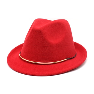 Detail of red wool felt fedora featuring a black band with a gold metal hardware accent
