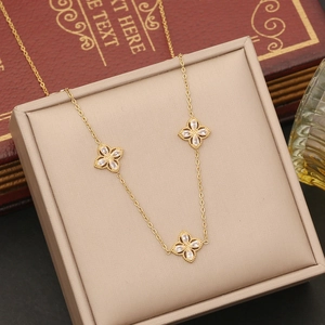 Detailed close-up of golden clover necklace with sparkling marquise zirconia on a jewelry tray