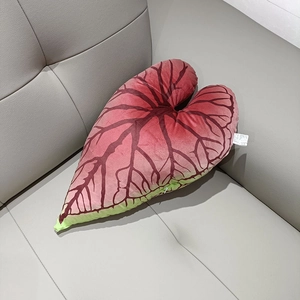 Detailed view of leaf-shaped plush pillow with realistic dark pink vein texture