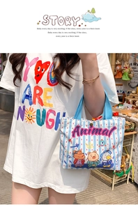 Outdoor street shot of a blue striped canvas tote bag with a cartoon animal print
