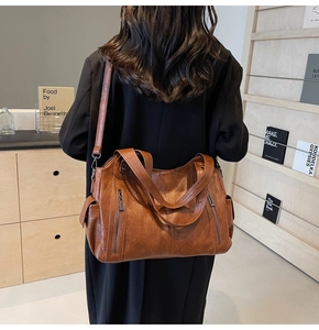 Brown vintage faux leather tote bag showing double zipper pockets and large side compartments