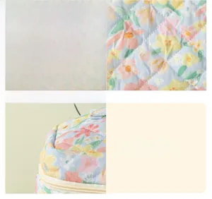 Detail view of floral quilted laptop sleeve showing premium stitching and zipper quality
