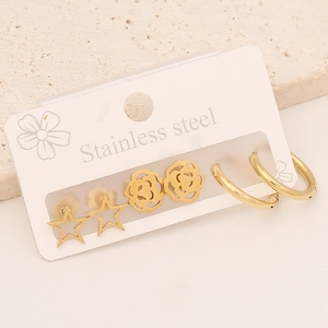 Detail view of gold stainless steel earring set featuring star and floral stud designs