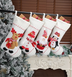 Detailed view of four white knitted Christmas stockings hanging on a wooden fireplace mantle