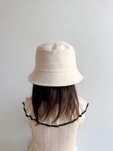 Detail view of cream cotton bucket hat for girls featuring a decorative bow on the back