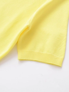 Close-up of fine-knit fabric texture and ribbed cuff detail on light yellow V-neck top