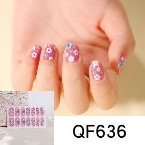 Macro view of pink floral nail stickers featuring blue and yellow heart patterns