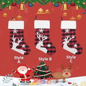 Detail of red and black plaid Christmas stockings with white reindeer and snowflake embroidery