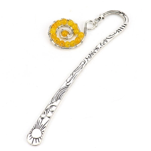 Macro detail of silver metal bookmark with yellow beads and sun star engravings