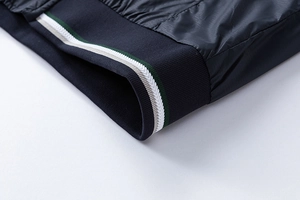 Macro view of navy jacket cuff with green and white striped elastic rib knit detail