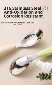 Close-up of 316L stainless steel baby training spoon with ergonomic cream and green handles