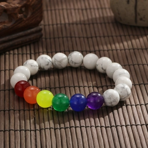 Vista macro di 7 perle chakra e pietre di marmo bianco su un tappeto di bambù