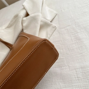 Sac cabas en cuir marron avec coutures détaillées à la base pour un design minimaliste chic