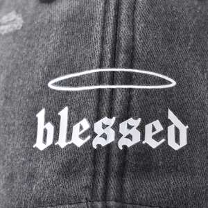 Washed dark grey cotton baseball cap featuring white Gothic blessed print and halo design